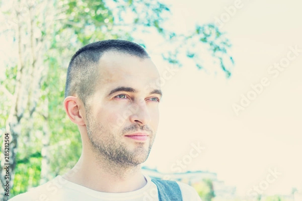 Fototapeta Attractive young man in Park in summer, look aside, portrait, close up, toned
