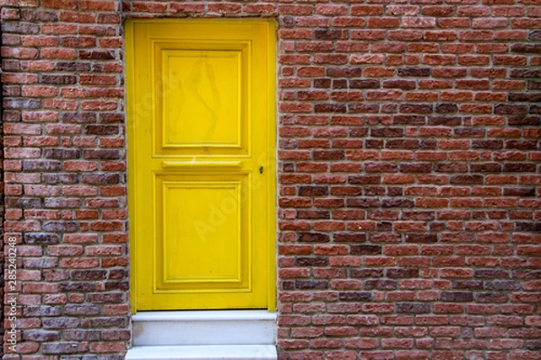 Fototapeta yellow door and orange brick wall in historic city Istanbul in Turkey