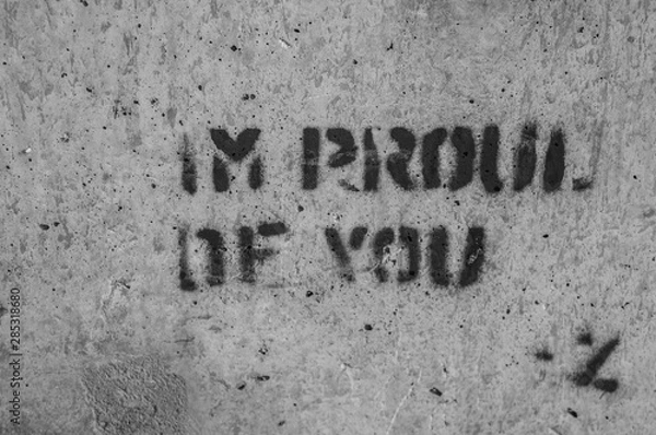 Obraz Black-and-white photo of a phrase reading, "I'M PROUD OF YOU" stenciled onto a concrete wall
