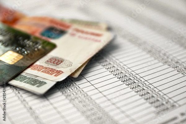 Fototapeta Money and credit card on a loan agreement paper form with loan repayment schedule.