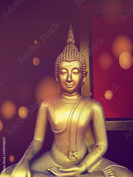 Fototapeta golden buddha statue, The face of gold buddha statue, Close up of the old Thai buddha with wooden wall background in art of religion concept