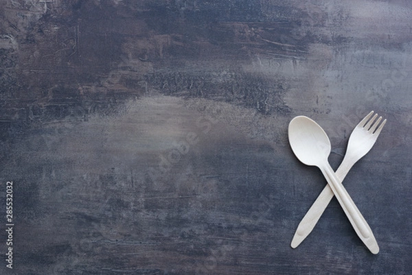 Obraz Top view of marble kitchen benchtop with wooden cutlery - crossed fork and spoon. Copy space for menu.