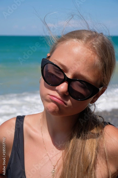 Fototapeta girl in sunglasses on the beach
