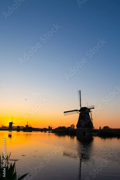 Fototapeta Beautiful Romantic Dutch Windmills in Front of The River in Kinderdijk Village in the Netherlands. Picture Taken At Golden Hour.
