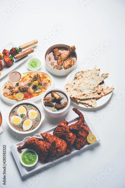 Fototapeta Assorted Indian Non Vegetarian food recipe served in a group. Includes Chicken Curry, Mutton Masala, Anda/egg curry, Butter chicken, biryani, tandoori murg, chicken-tikka and naan/roti for ramadan