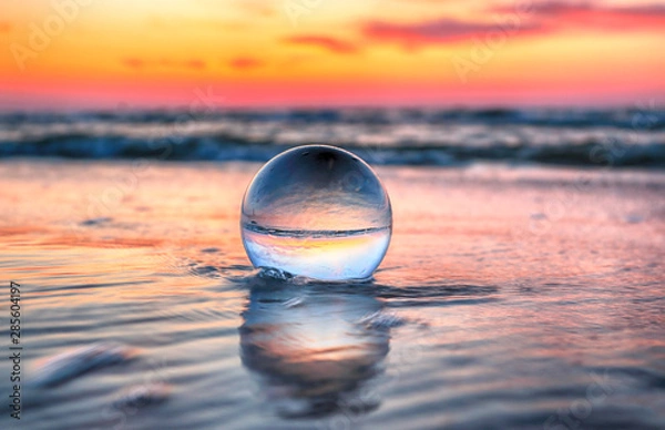 Obraz Piękny zachód słońca na plaży w Słowińskim Parku Narodowym koło Łeby. Widok przez szklaną, kryształową kulę (kula soczewkowa) do fotografii refrakcyjnej. Dzika, nietknięta przyroda.