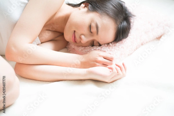 Fototapeta ベッドで眠る若い女性