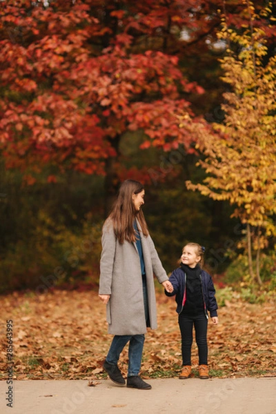 Fototapeta Two sisters walk in the park in autumn time. Childhood. season and people consept-happy family. Portrait of happy sisters in forest