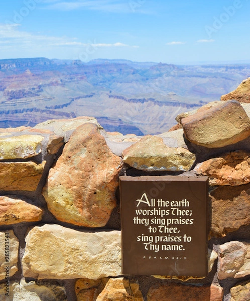 Obraz "All the earth worships Thee; they sing praises to Thee, sing praises to Thy name." Psalm 66:4. Plaque in the foreground in focus with the Grand Canyon landscape in the background