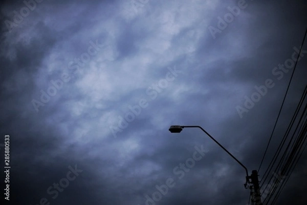Fototapeta home level Voltage electric power lines. silhouette electrical light pole and cloudy dusk sky. city power supply and power consumption concepts. dark nightfall and light is not lit up
