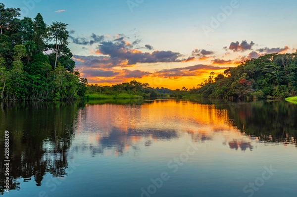 Fototapeta Reflection of a sunset by a lagoon inside the Amazon Rainforest Basin. The Amazon river basin comprises the countries of Brazil, Bolivia, Colombia, Ecuador, Guyana, Suriname, Peru and Venezuela. 