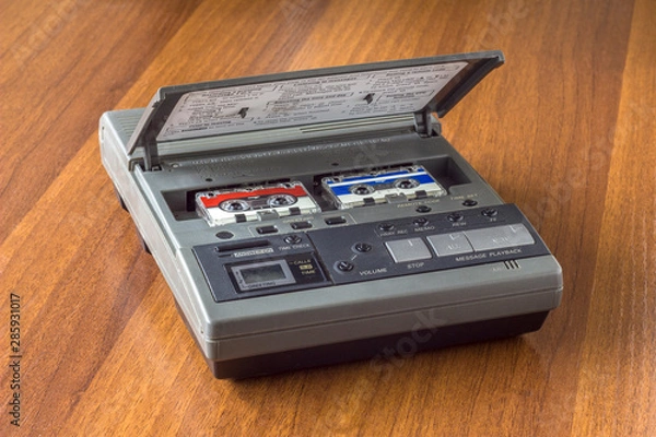 Fototapeta old vintage answering machine with two small tape cassettes on a wooden table surface
