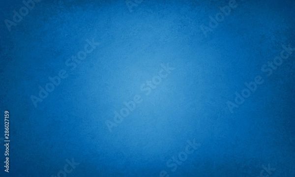 Fototapeta Blue background with faint texture and bright center and black vignette border, elegant luxury sapphire blue color in old vintage layout