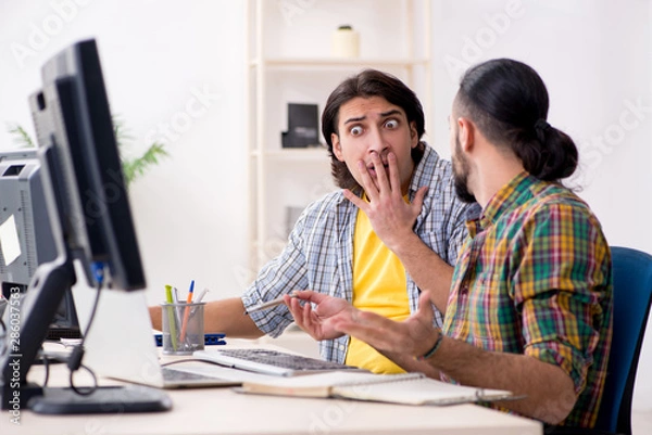 Fototapeta Two it specialists working in the office