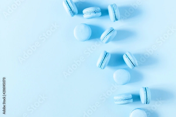 Fototapeta Light blue macaroons on pastel blue background. Sweet background. Flat lay, top view, copy space