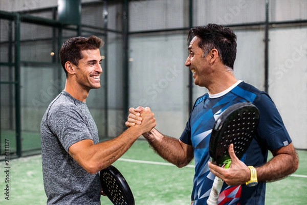 Fototapeta two padel players shaking hands after win a padel match