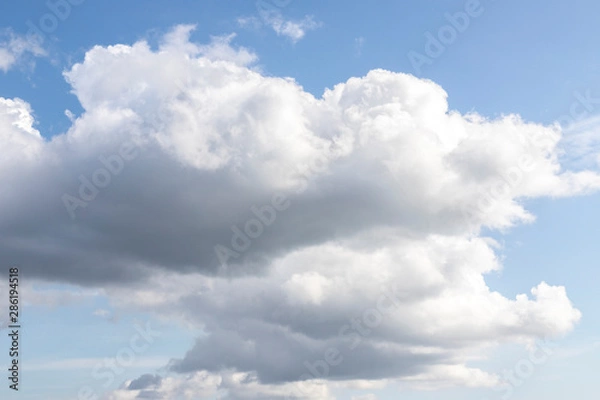 Fototapeta Blue sky with white clouds. Big dark cloud on the blue sky. Cloudy daytime weather. Background with free space and empty place.