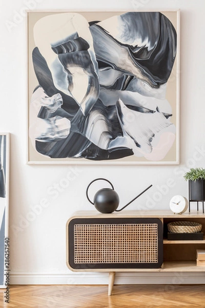 Fototapeta Interior design of living room at nice scandinavian apartment with stylish commode, watering can, abstract paintings, plant nd elegant accessories. Modern home decor. Template. Mock up. White walls.