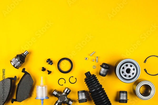 Fototapeta Set of car parts for maintenance on yellow background