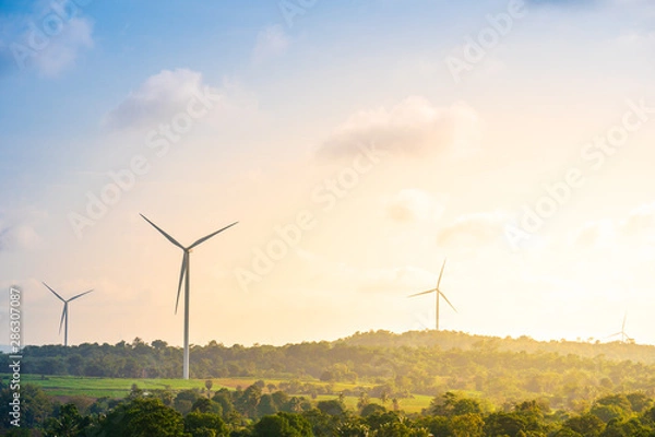 Fototapeta Green energy concept, eco power. Wind turbine located along the hill with the wind blowing all the time. Can produce renewable energy as well. Considered a clean energy.