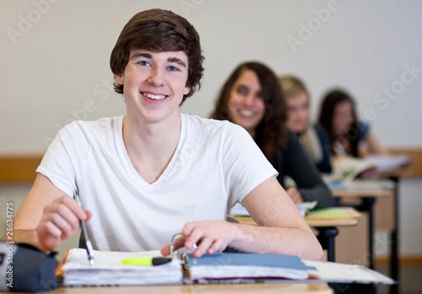Fototapeta Student working on homework in classroom