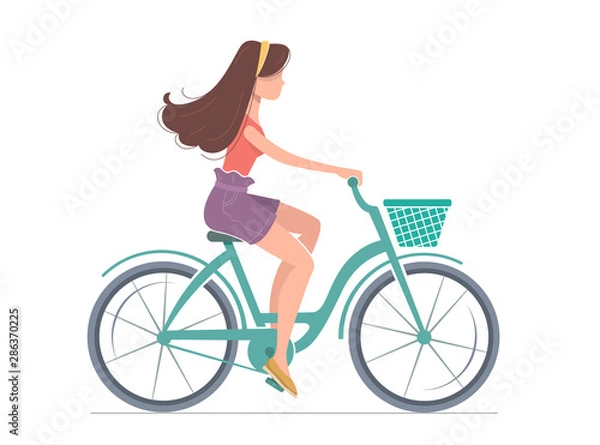Fototapeta Young woman is riding a bicycle.