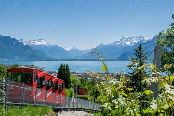 Fototapeta Red cable car on the top of mountain with the view on Lake Geneva and Alps mountains
