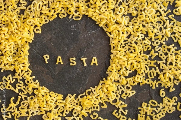 Fototapeta Pasta Alphabet and ingredient for sauce (set of ingredients, raw pasta) serving second course. top food background. copy space