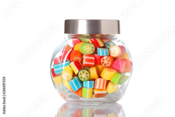 Fototapeta a glass jar half  full of colored candies with copy space isolated on white background with clipping path