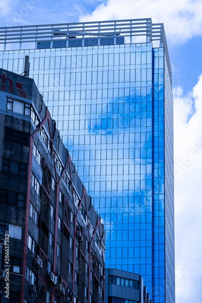 Obraz 高層ビルに溶け込んだ青空と白い雲