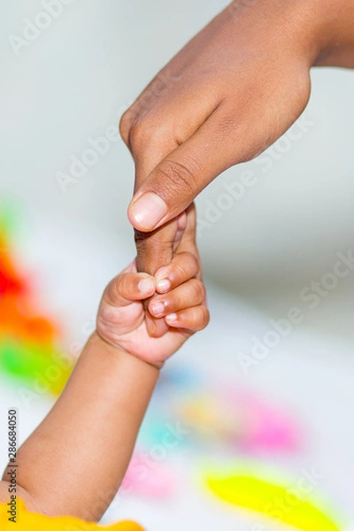 Fototapeta A asian baby's hand holding her mother finger