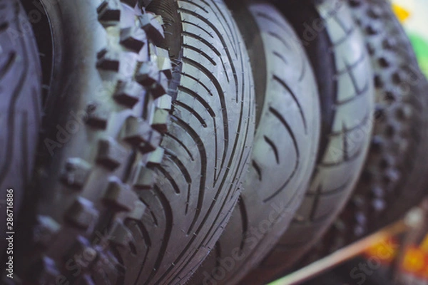 Fototapeta motorcycle tires in a assortment of a store are arranged in a row close-up. sale