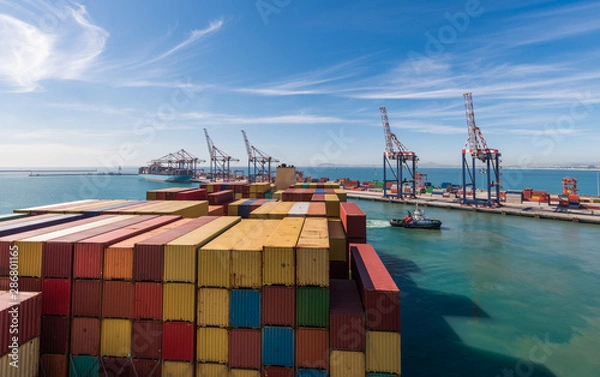 Obraz Large stacked container ship in the Ben Schoeman dock, leaving the port of Cape Town with tug assistance, South Africa.