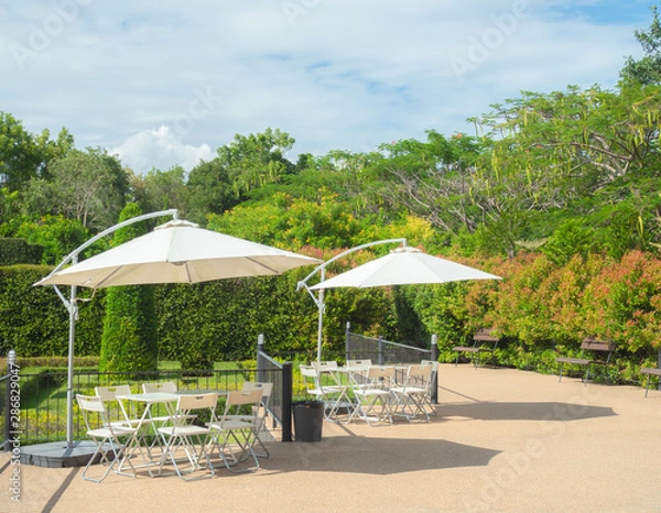 Fototapeta Garden umbrella outdoor with table and chairs in garden