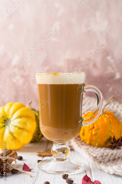 Fototapeta Cup of pumpkin spice latte with whipped cream on top and seasonal autumn spices, and fall decor. Traditional coffee drink for autumn or winter holidays, copy space.