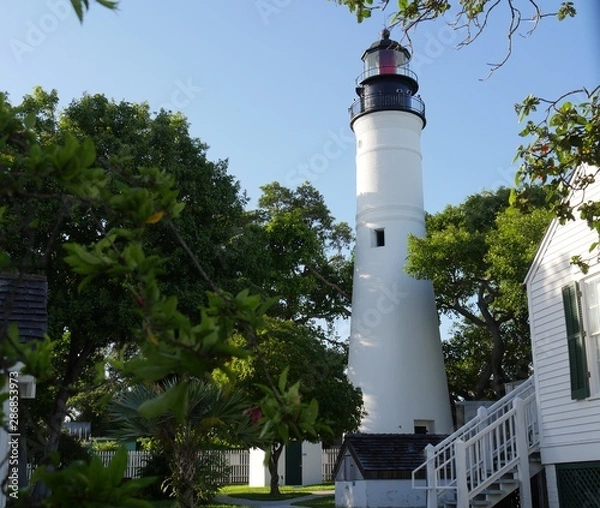 Fototapeta Wide shot of the Key West lighthouse with part of the keeper's quarters in view. The lighthouse is a historical attraction in Key West, Florida.