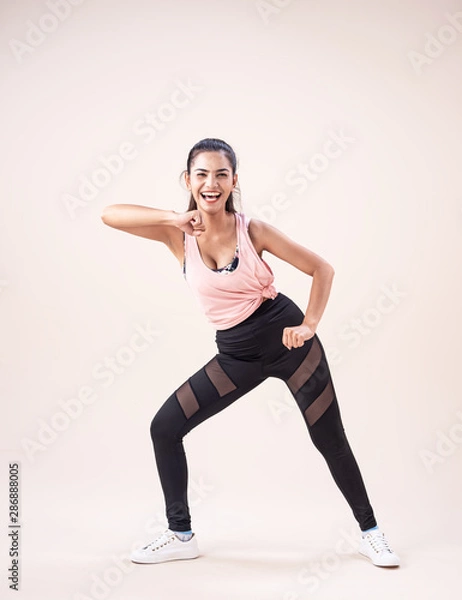 Fototapeta The young woman wearing exercise suit,doing dance workout,for exercise,with smile and happy feeling,