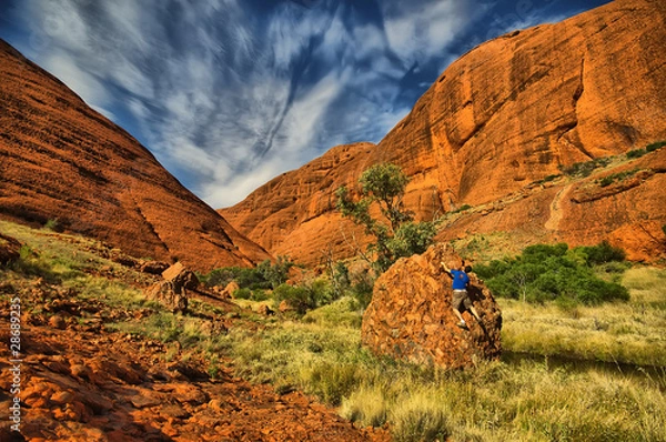 Obraz hombre escalando roca naranja