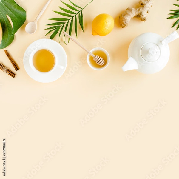 Fototapeta Herbal tea with mint, ginger, lemon, honey and other herbs on yellow background. Flat lay, top view.