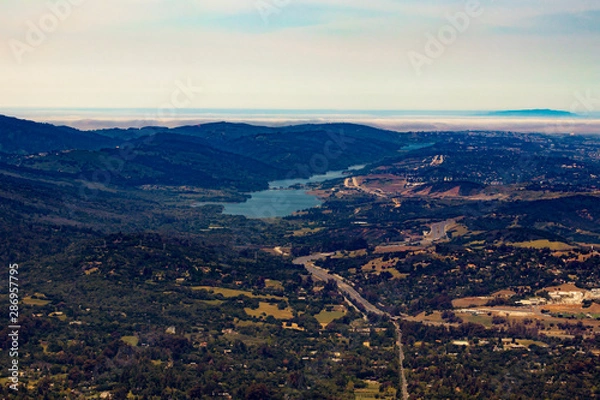Obraz Aerial View Flying over San Mateo County with a Lake and the Foggy Marine Layer in the Horizon in the San Francisco Bay Area, California, USA