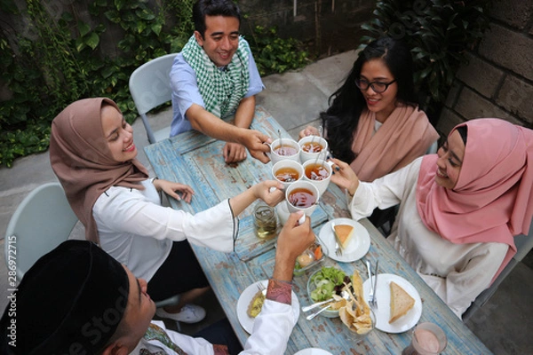 Fototapeta top view of a group friends having tea toast at table dining during ramadan celebration