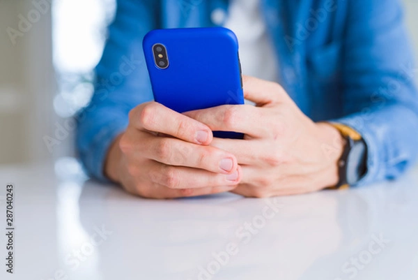 Fototapeta Close up of man hands using smartphone and smiling