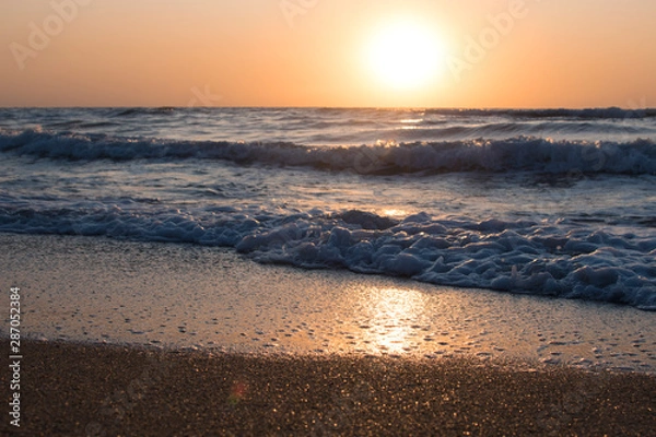 Obraz Sunset or dawn on the sea, waves and the sun.