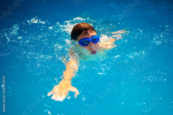 Obraz BOY WITH GOGGLES EXERCISING FREESTYLE SWIMMING AND BREATHING