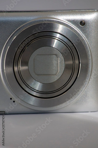 Fototapeta Close-up Silver digital compact camera with a closed lens. space for signature
