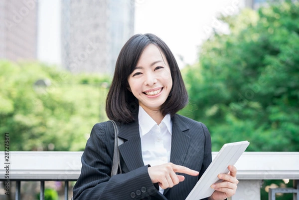 Obraz Young business woman using tablet computer outside