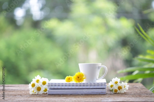 Obraz White coffee cup with Chrysanthemum flowers and notebooks on wooden table at outdoor