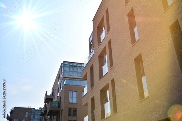 Fototapeta Modern apartment buildings on a sunny day with a blue sky. Facade of a modern apartment building.Glass surface with sunlight.