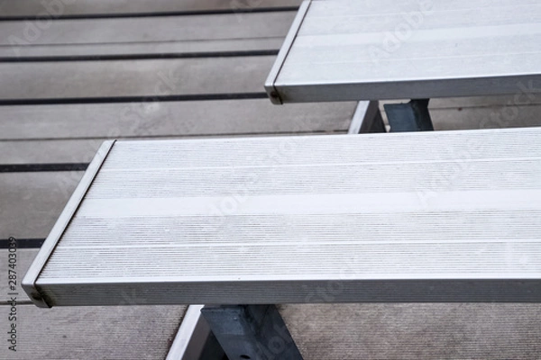 Fototapeta Empty metal bleachers seats in football, soccer or baseball stadium during local game