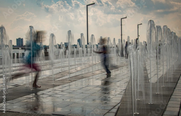 Obraz Children running through a fountain in Summer